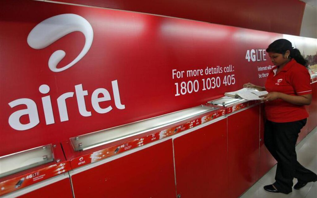 An employee checks a customers feedback book next to a Bharti Airtel logo inside its shop in Kolkata May 2 2012